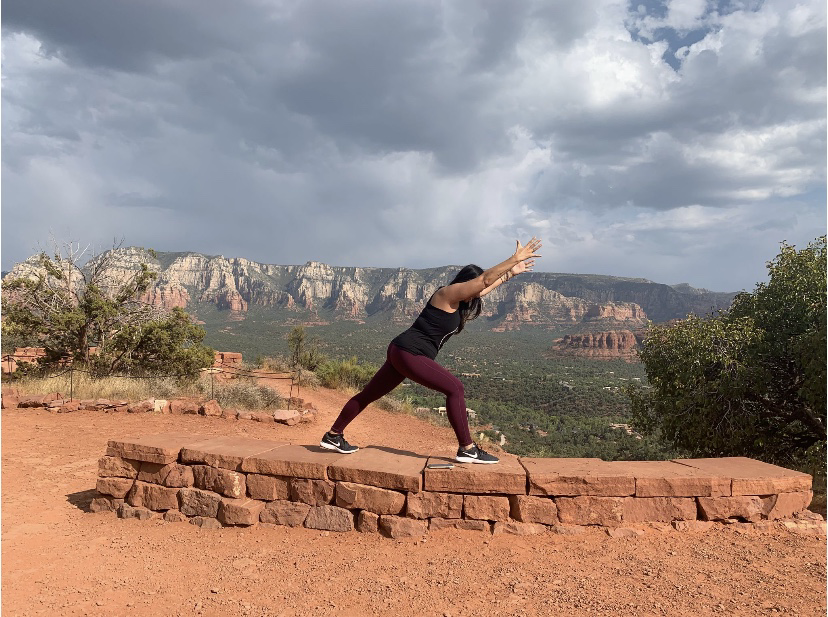 Judy Thureson reaching upward on the red rocks of Sedona